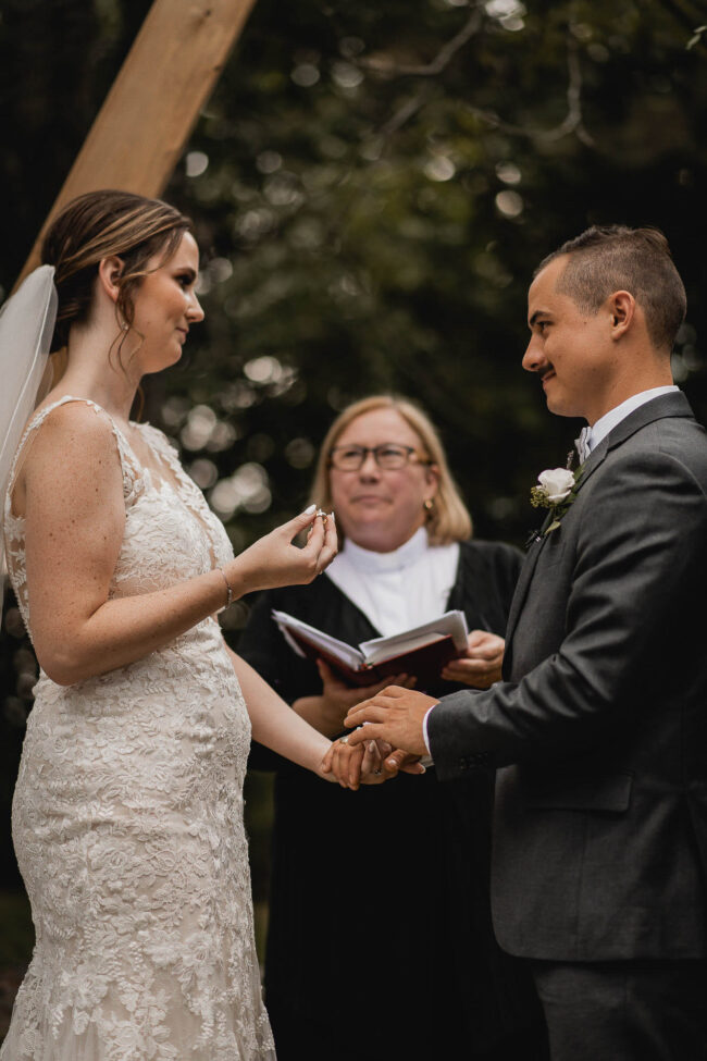 bride putting ring on groom
