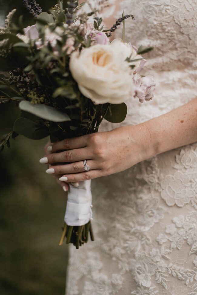 ringed hand holding wedding bouquet