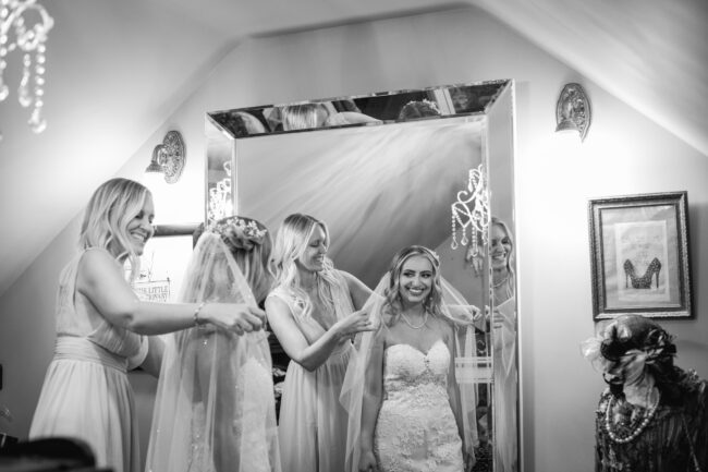 mom putting veil on bride on daughter's wedding day