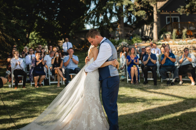 first kiss at wedding ceremony with guests in the background