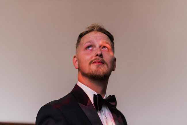 groom looking at stained glass windows in church
