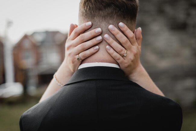bride holding groom's head in hands