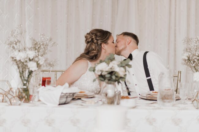 bride and groom kiss during wedding reception