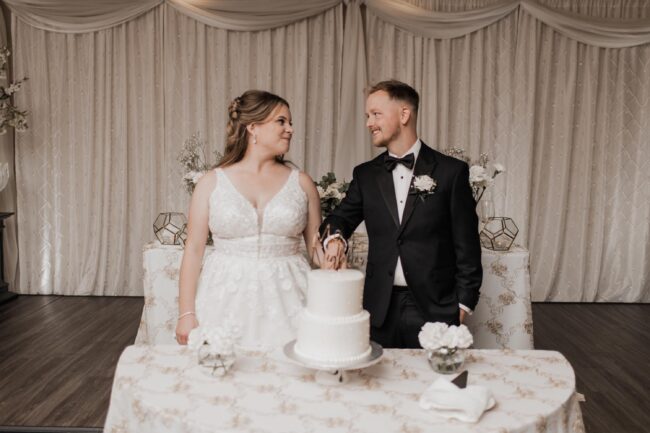bride and groom cut wedding cake