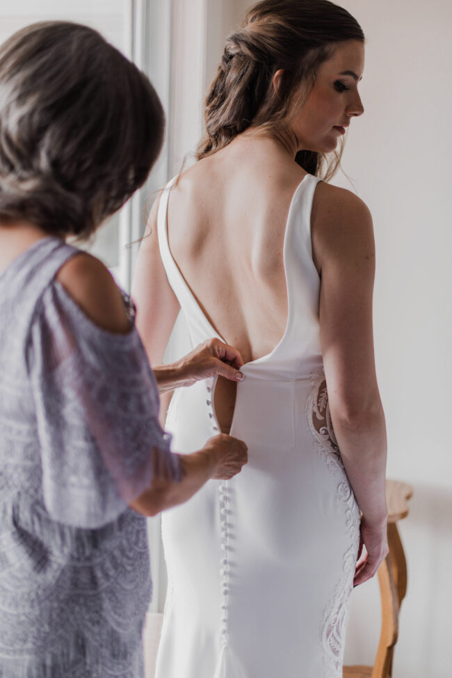 mother of the bride helping with wedding dress