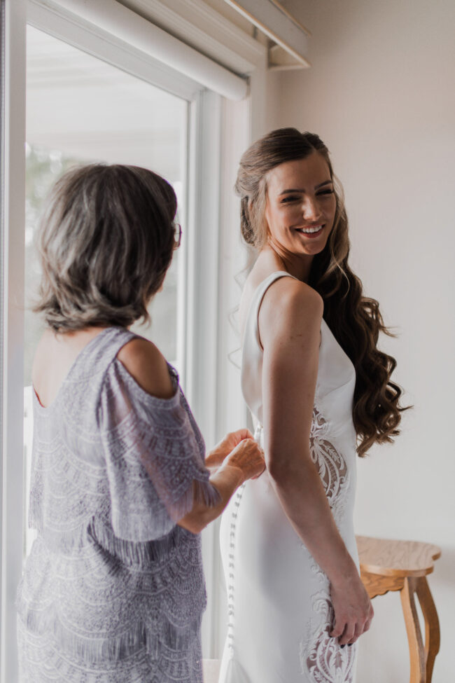mother of the bride helping with wedding dress
