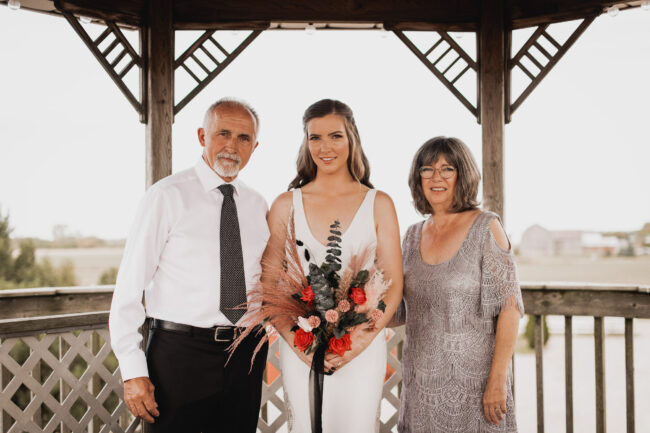 bride with parents on wedding day