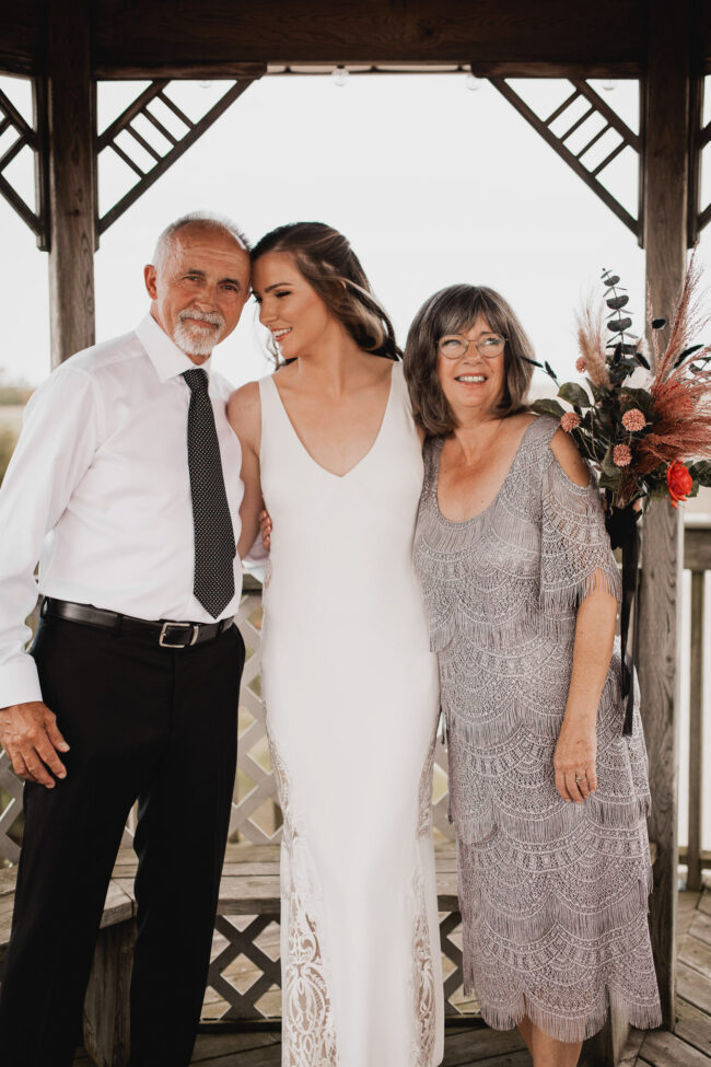 bride with parents on wedding day